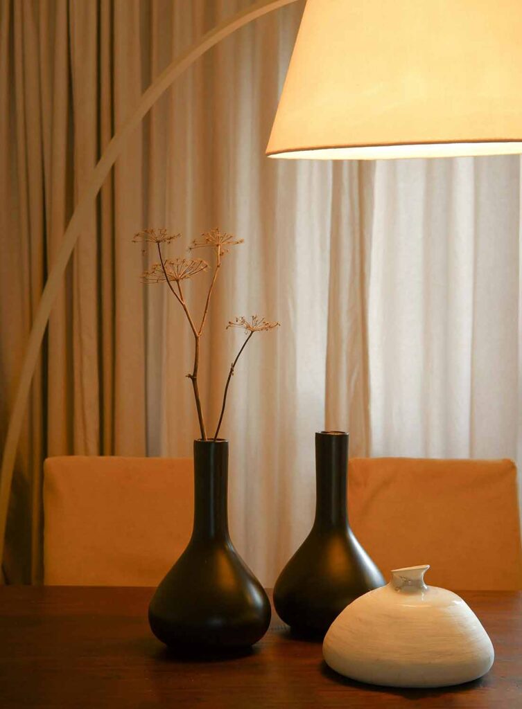 Minimalistische Tischdeko mit schwarzen und weißen Vasen unter warmem Licht