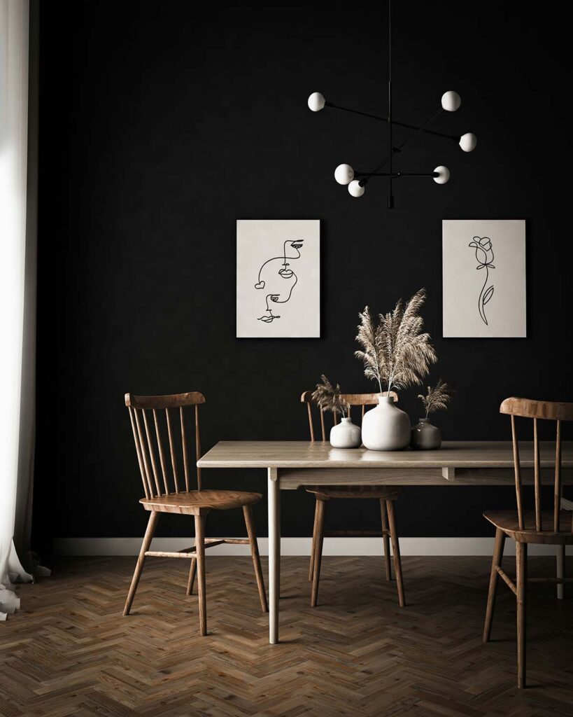 Minimalistisches Esszimmer mit schwarzer Wand, Holztisch und Deko aus Trockenblumen