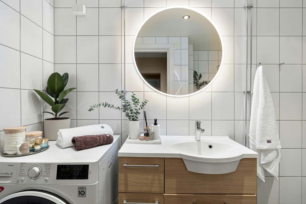 Modernes kleines Bad mit Waschmaschine, Holzwaschtisch und rundem L