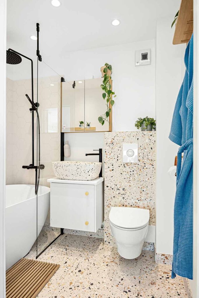 Helles kleines Bad mit Badewanne, Glaswand und Pflanzen – modernes Design mit natürlichen Akzenten.
