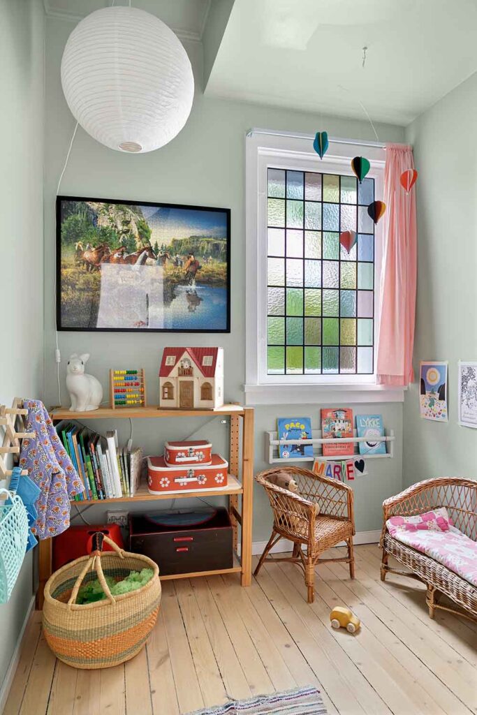 Liebevoll eingerichtete Spielecke mit Regalen, Körben und kleinen Möbeln im Kinderzimmer