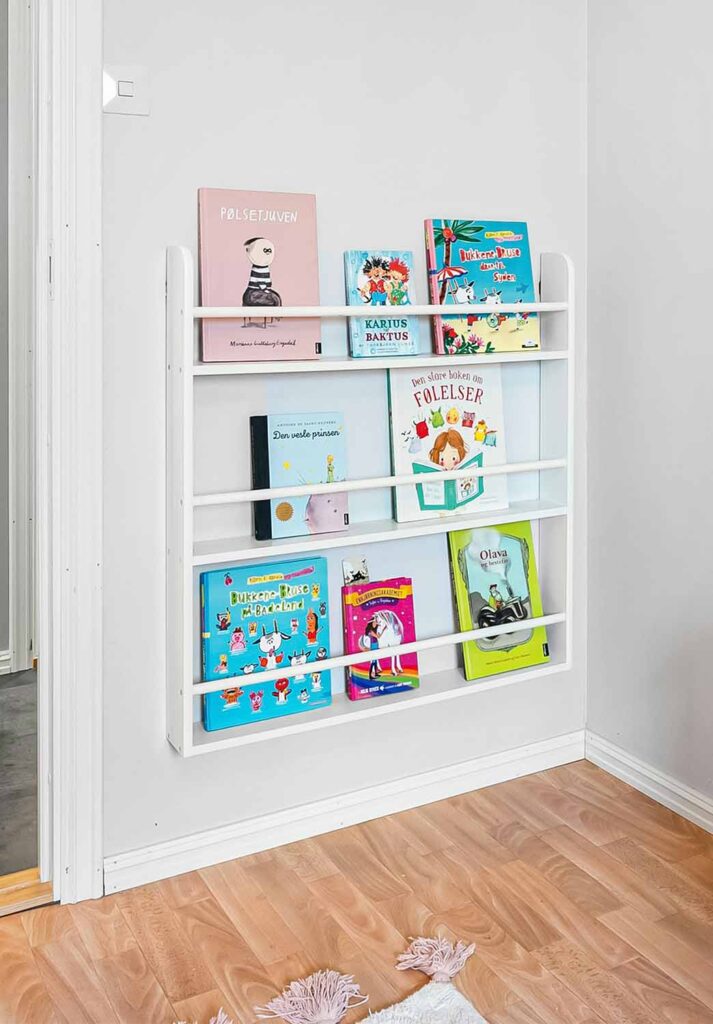 Bodennah aufgehängtes Wandregal mit frontaler Bücheraufbewahrung im Kinderzimmer