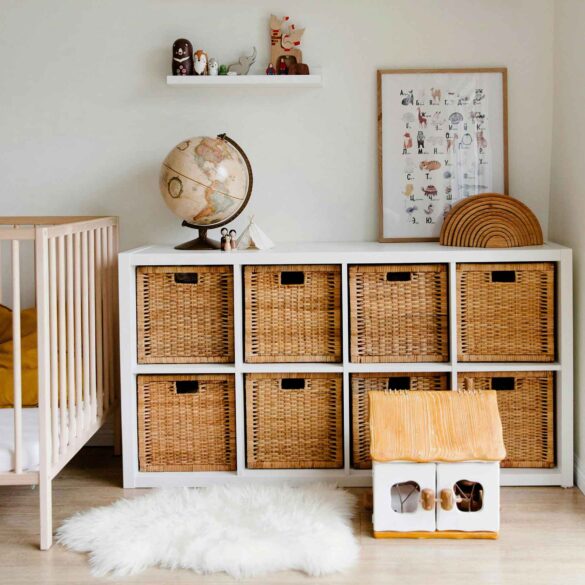 A bright kids' room with baskets on a freestanding shelf and decor in natural tones