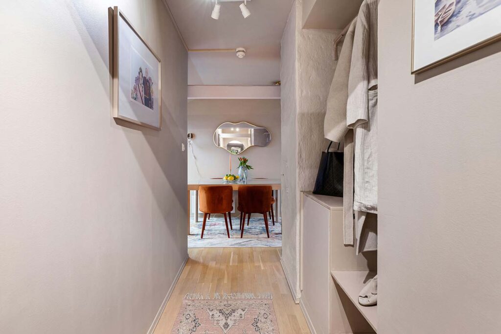 Schmaler Flur mit Einbaunische, offener Garderobe, Teppichläufer und Blick in den Essbereich