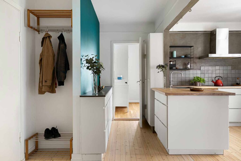 Offener Wohnungsflur mit Wandgarderobe, Schuhablage, Stauraum und Übergang zur Küche